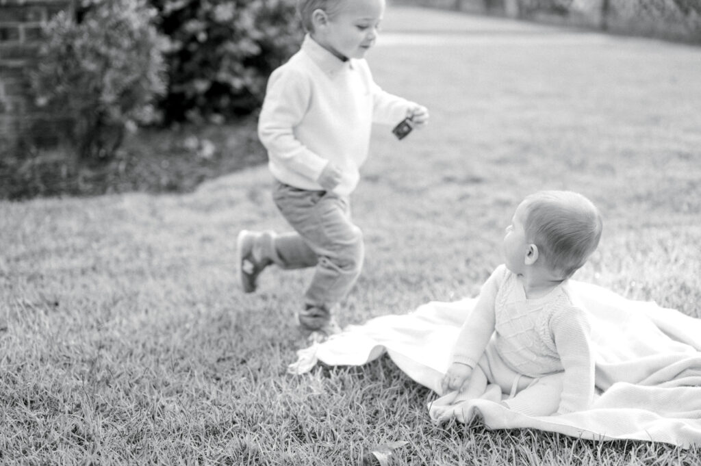 two little boys on a blanket in the yard