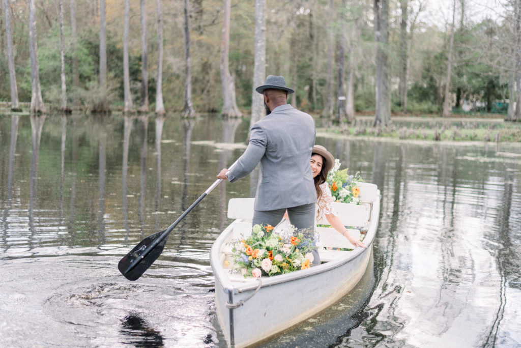 Luxury engaged couple in a Notebook style rowboat at Cypress Gardens 