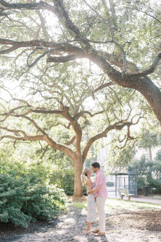 Couple kissing under live oak tree in Washington Square in downtown Charleston at sunset