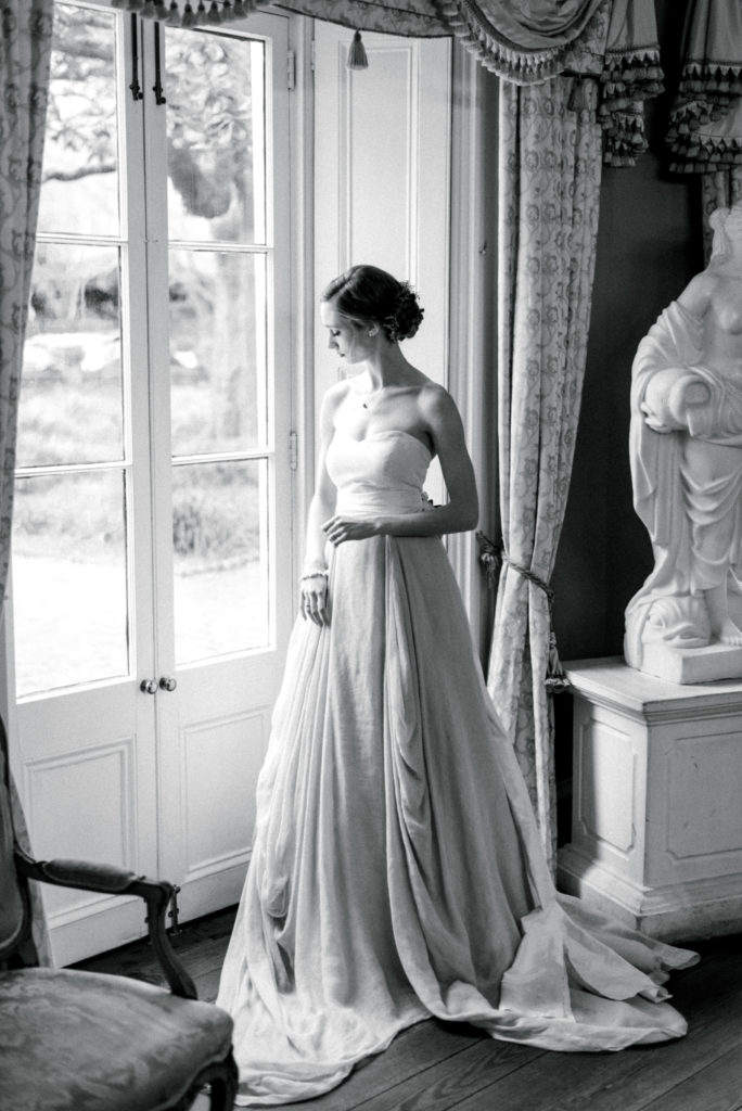 Black and White image of bride by a window at the William Aiken House