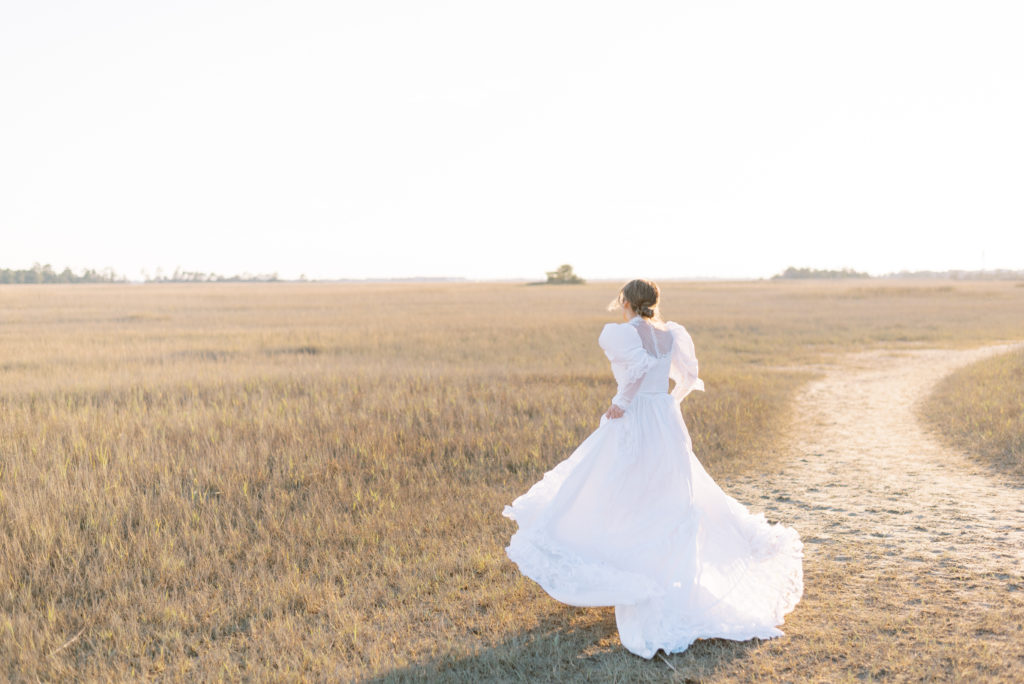 Bride running into the sunset in golden grass on the marsh in Charleston South Carolina