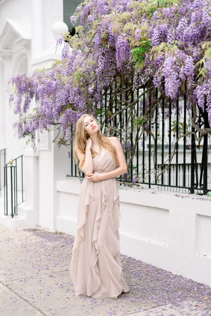 Woman in lavender in front of blooming wisteria in Charleston in March photographed by Kelsey Halm Photography