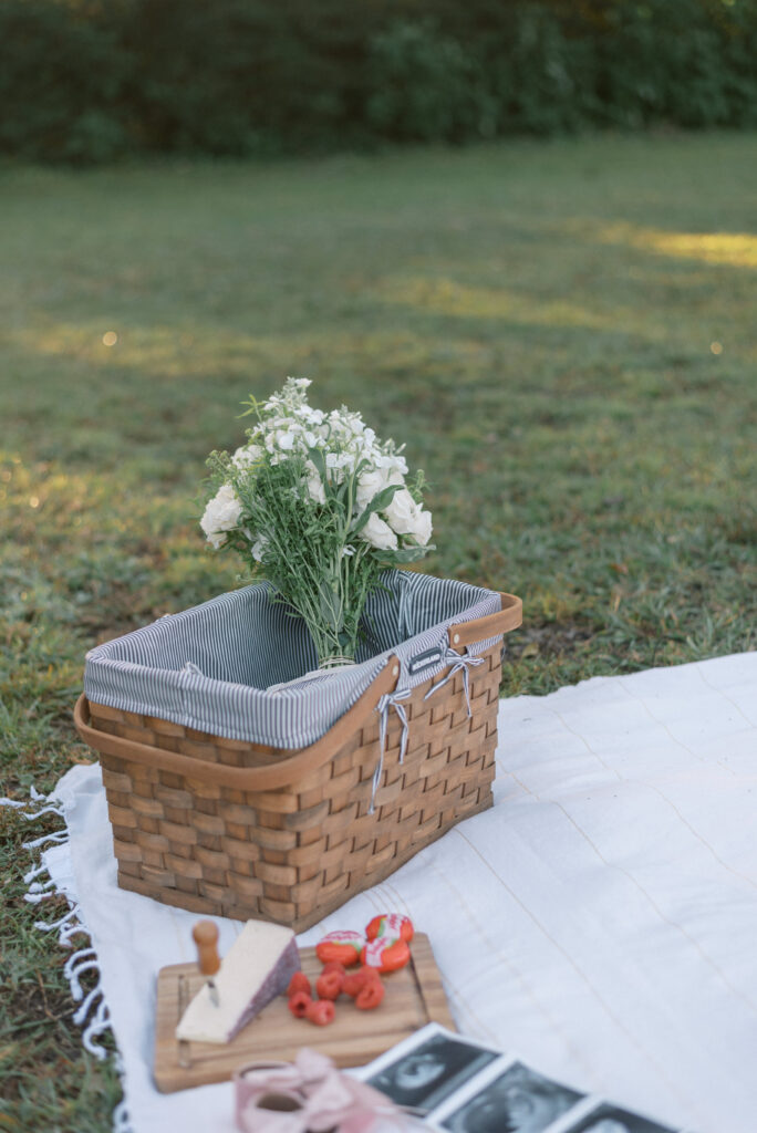 Picnic basket with white flowers on a white blanket