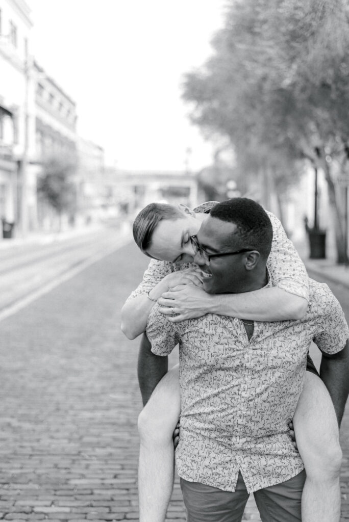 man giving his partner a piggy back ride photographed in black and white