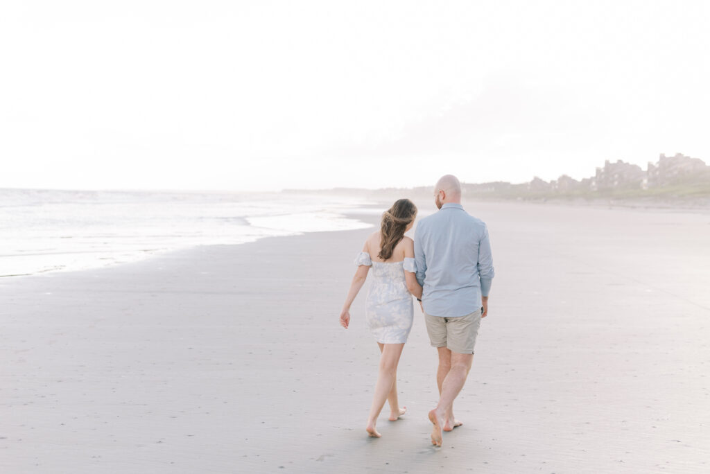 couple leaning on each other and holding hands walking down kiawah beach