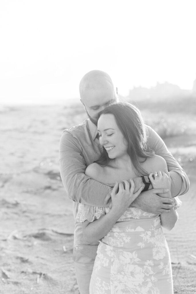 engaged couple hug and lean on each other captured in black and white
