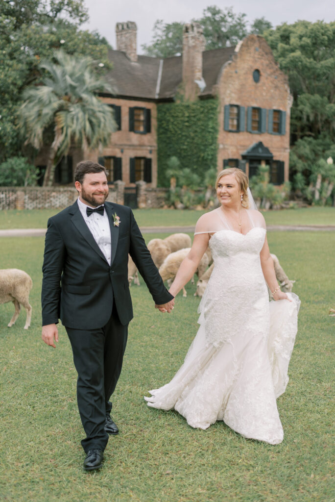 Bride and groom walk hand in hand and smile at each other at Middleton Place