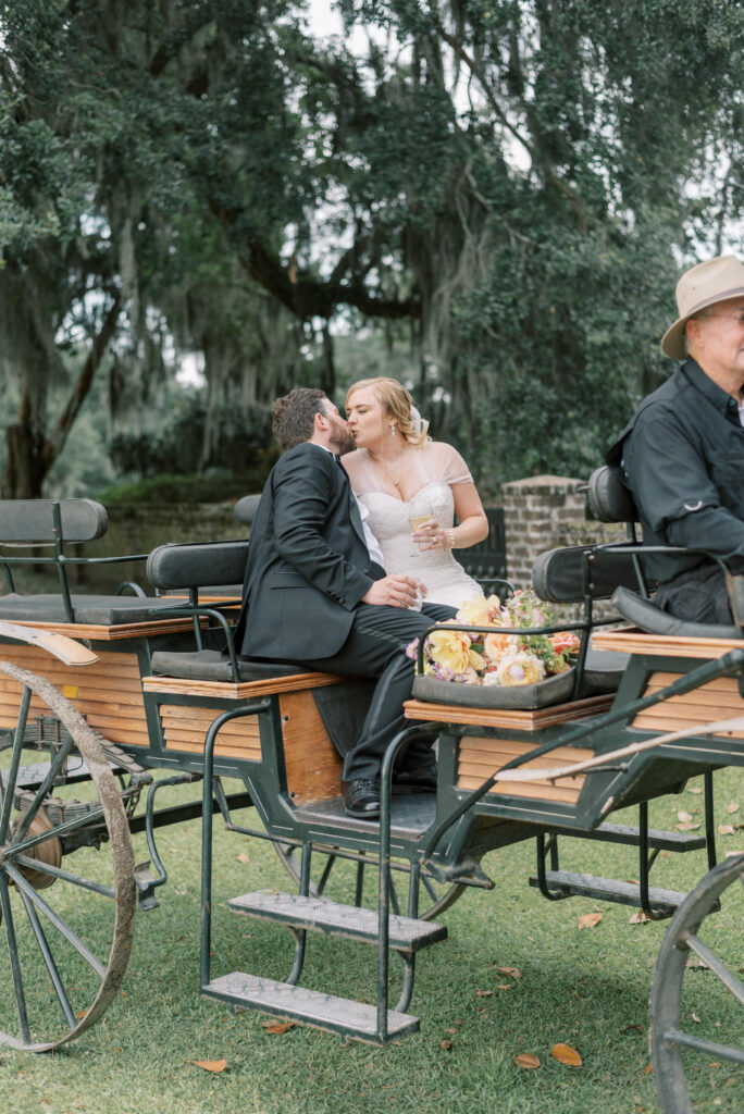 Bride and groom share a kiss in the carriage at middleton Place