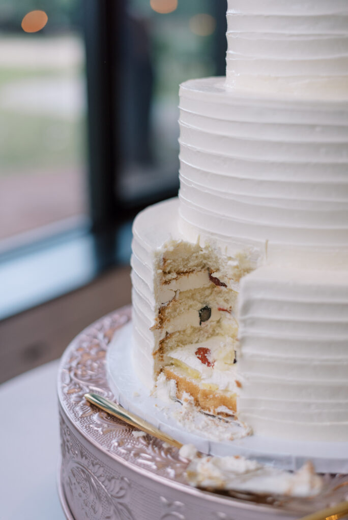 Cut side of a wedding cake with berries and cream