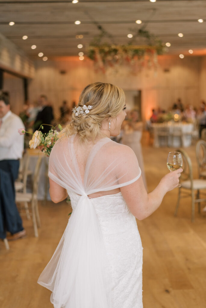 Bride dances her way into her reception holding a glass of wine