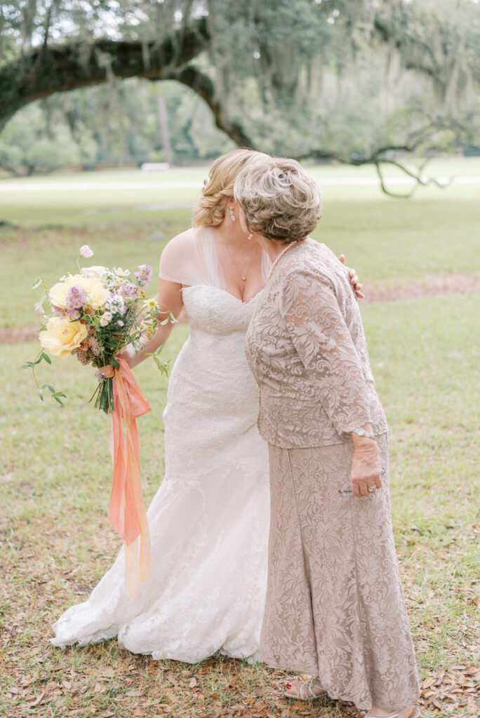 bride kisses her grandma on the cheek under the oaks at Middleton Place