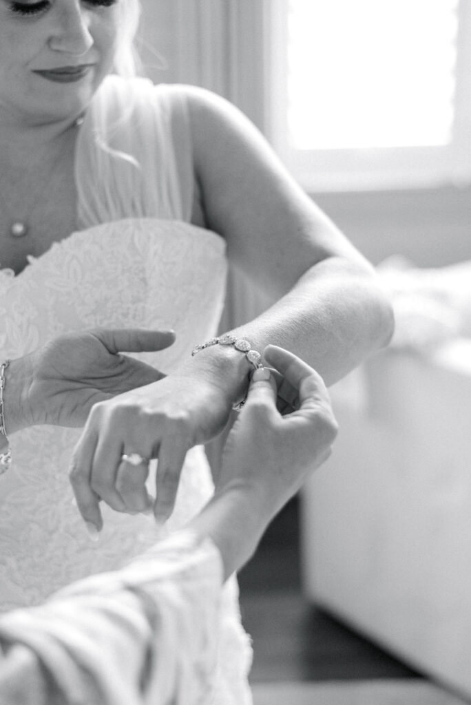 Bride's mother putting an heirloom bracelet on her for her wedding day