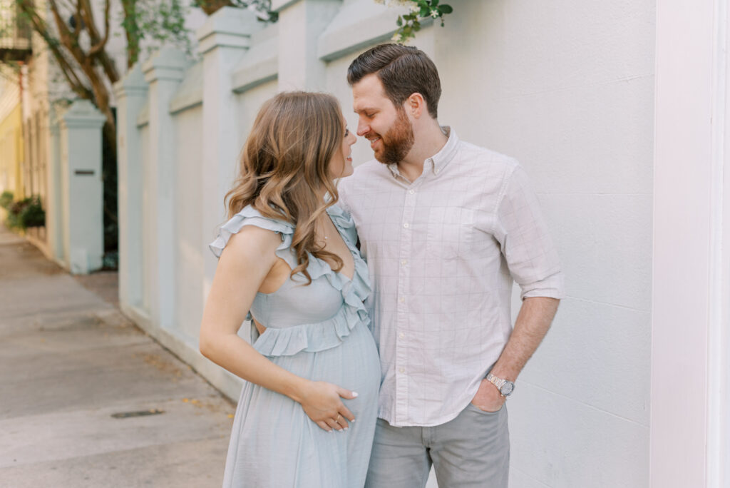 pregnant woman and her husband nose to nose smiling in Charleston
