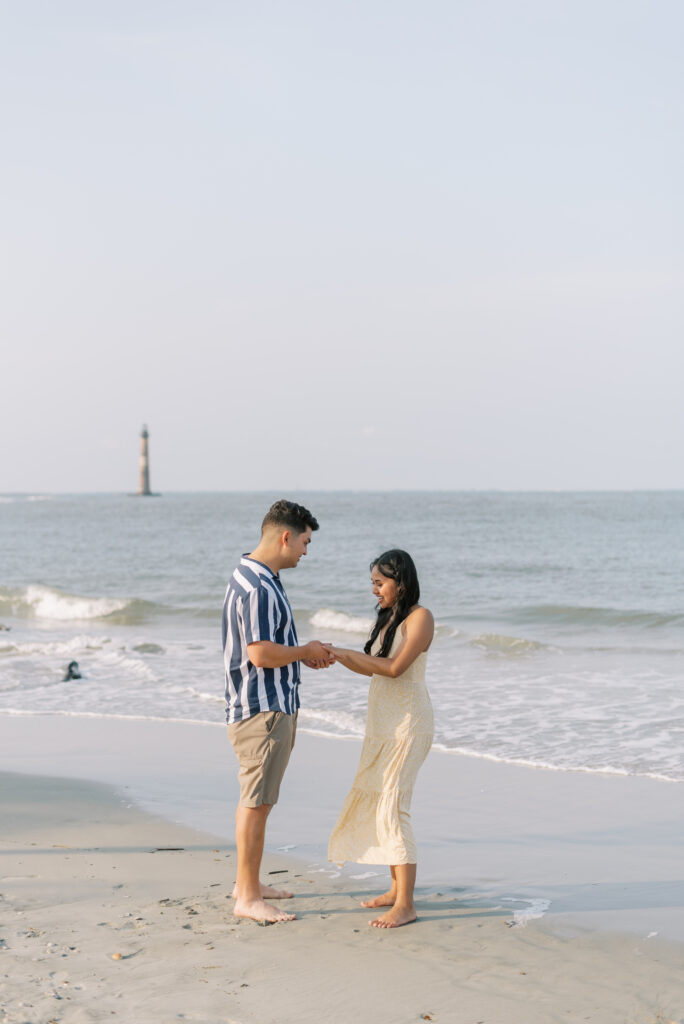 couple holding hands after just getting engaged at Folly Beach