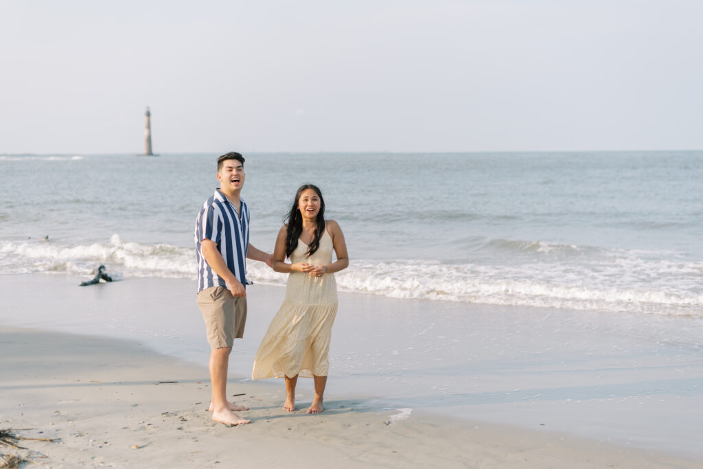 Couple laugh in surprise after a surprise proposal at Folly Beach
