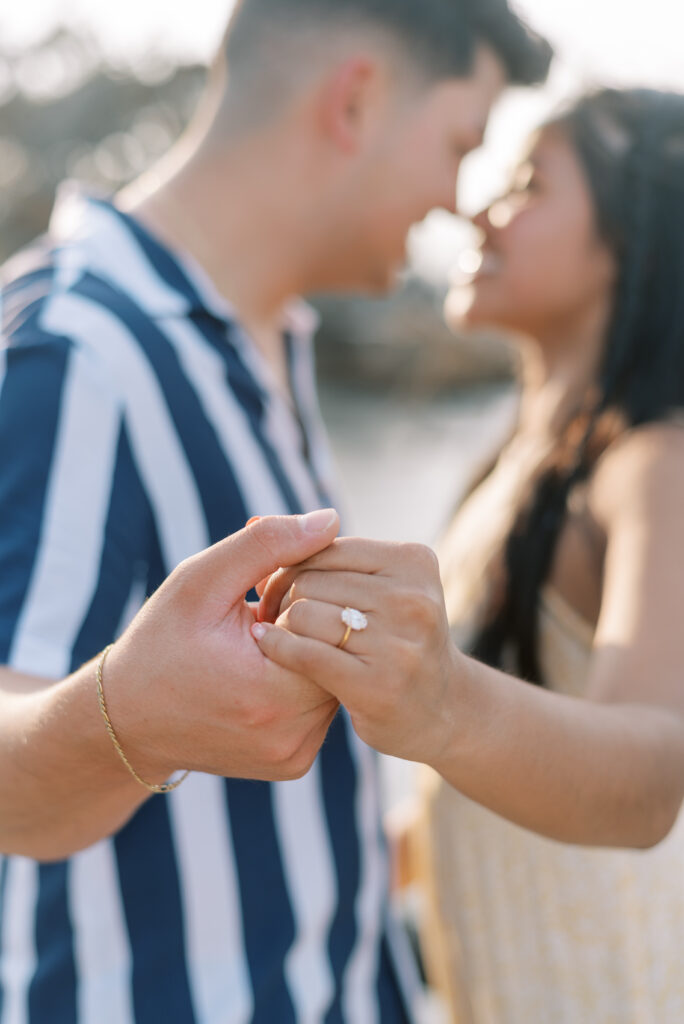 Close up of an engagement ring on a couple's hand just after a proposal