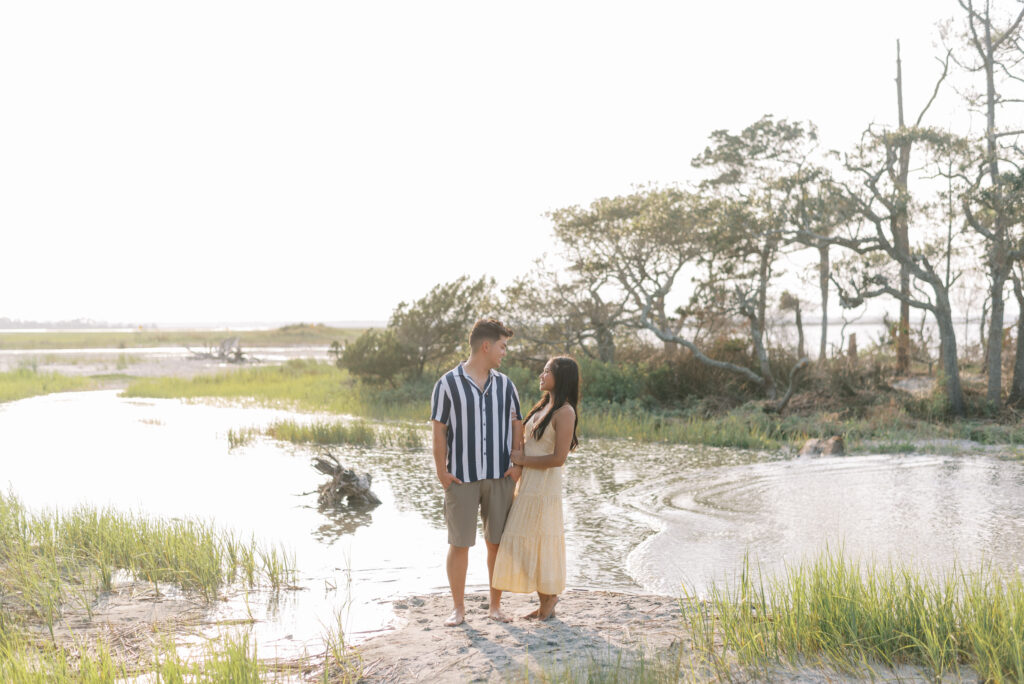 Couple smile together standing at the water at the inlet at Folly Beach