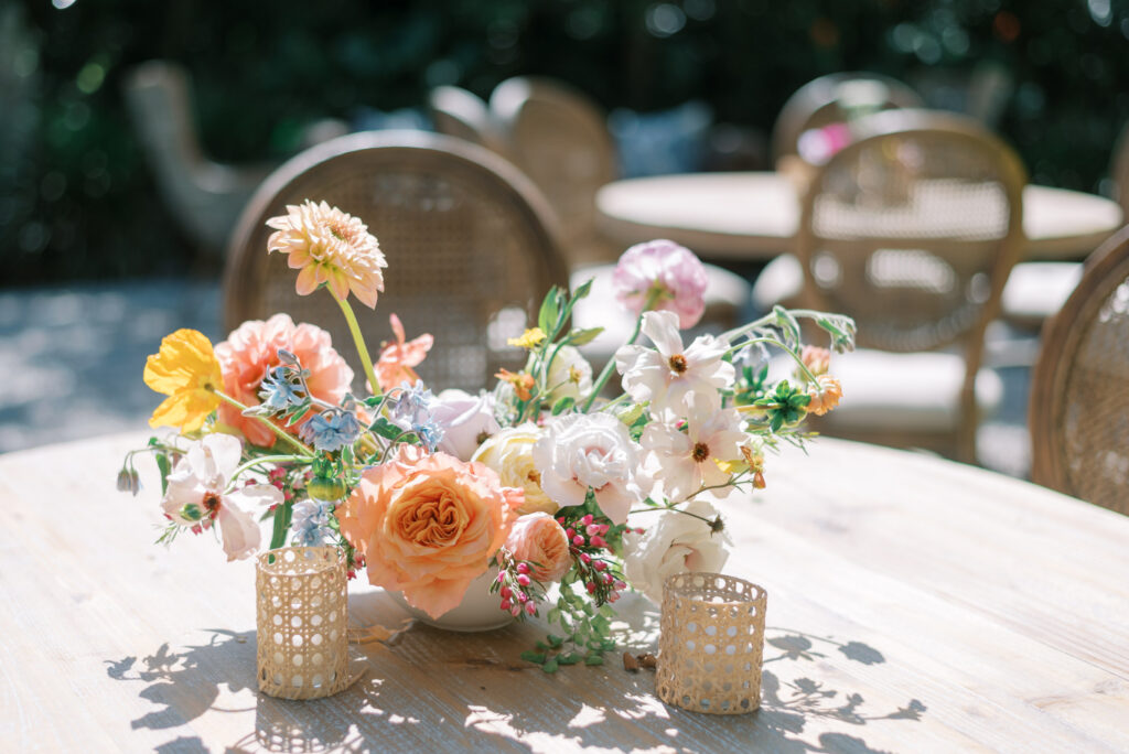 Peach Pink and Blue floral centerpiece on an outdoor wedding table 