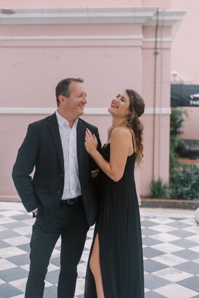 engaged couple laugh together during their engagement photos in Charleston