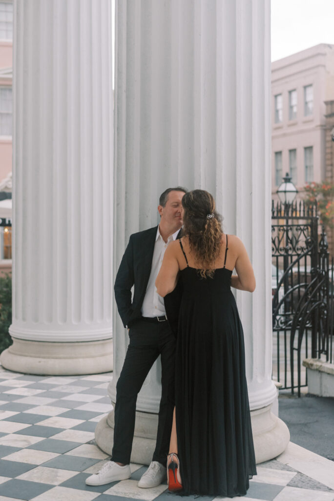 Couple kiss on a porch during their engagement session in Charleston