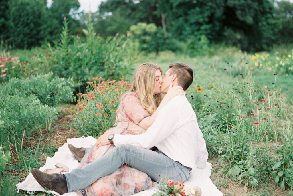 Couple kissing sitting amid flowers in Charleston
