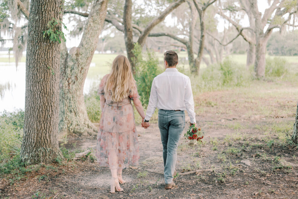 Couple holds hands walking by the marsh in South Carolina