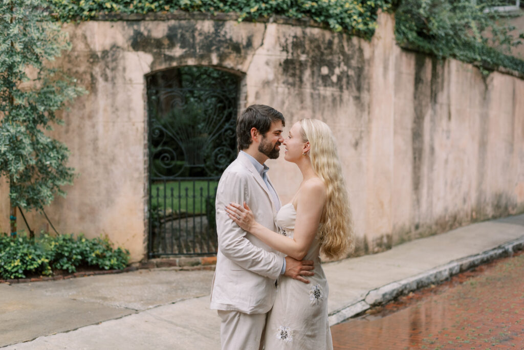 Couple almost kiss on a brick street in Historic Charleston during engagement photos