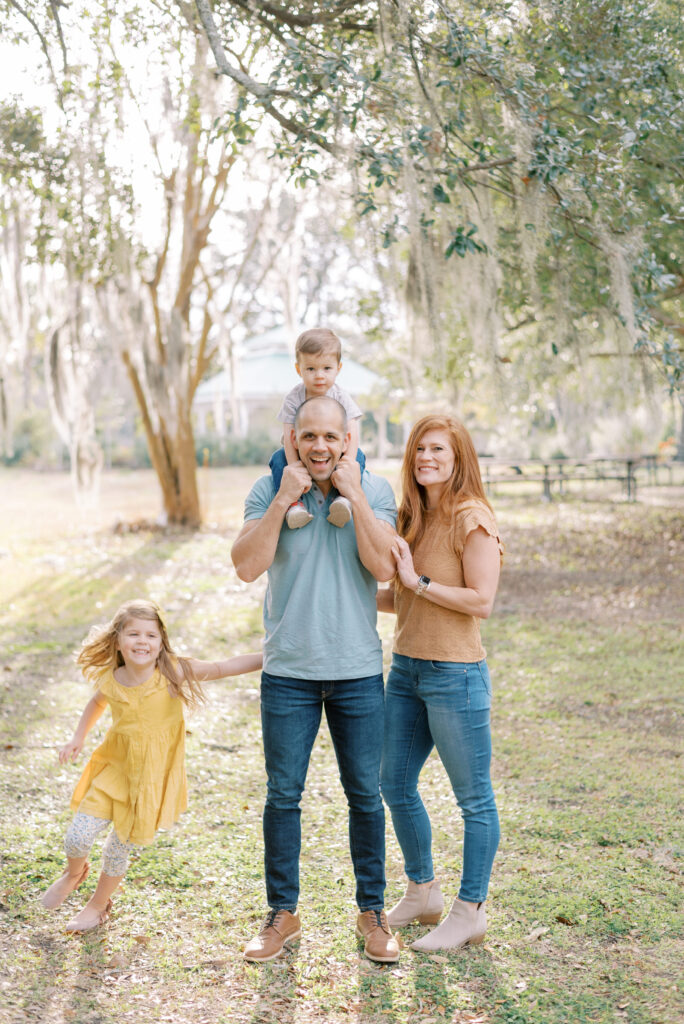 Family of four smile at the camera during their family photo session in Charleston