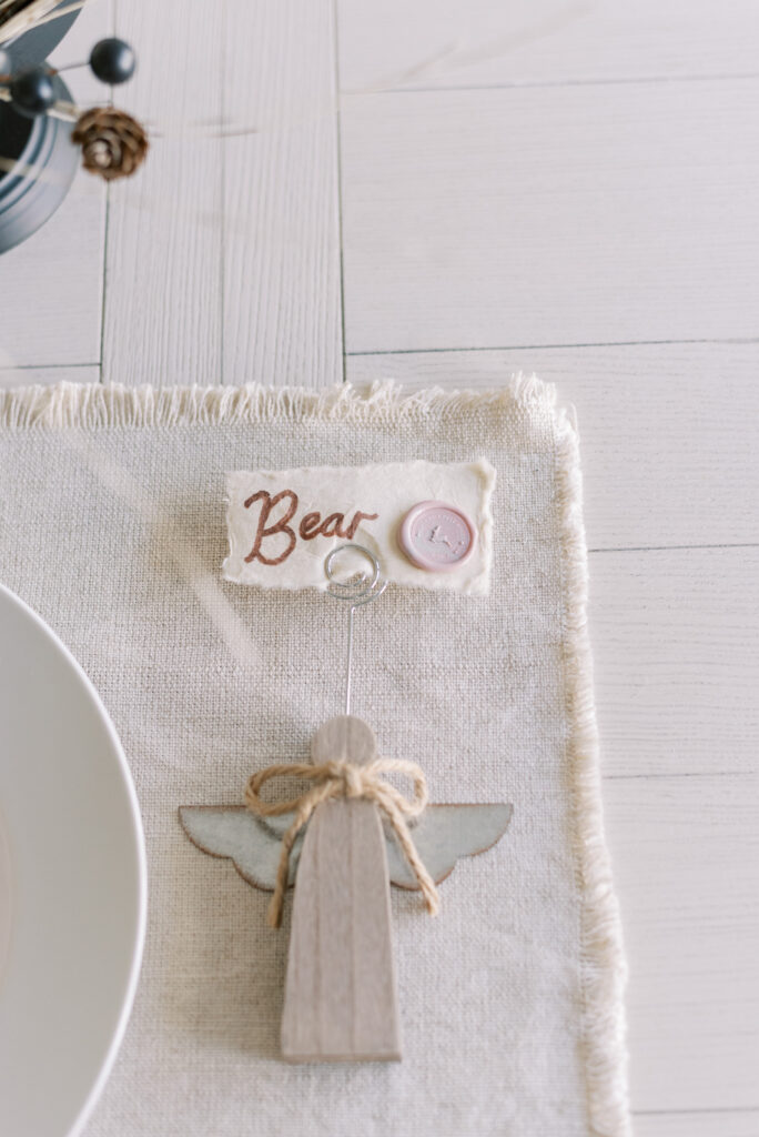 Neutral Christmas place setting with pink wax seal and wooden angel