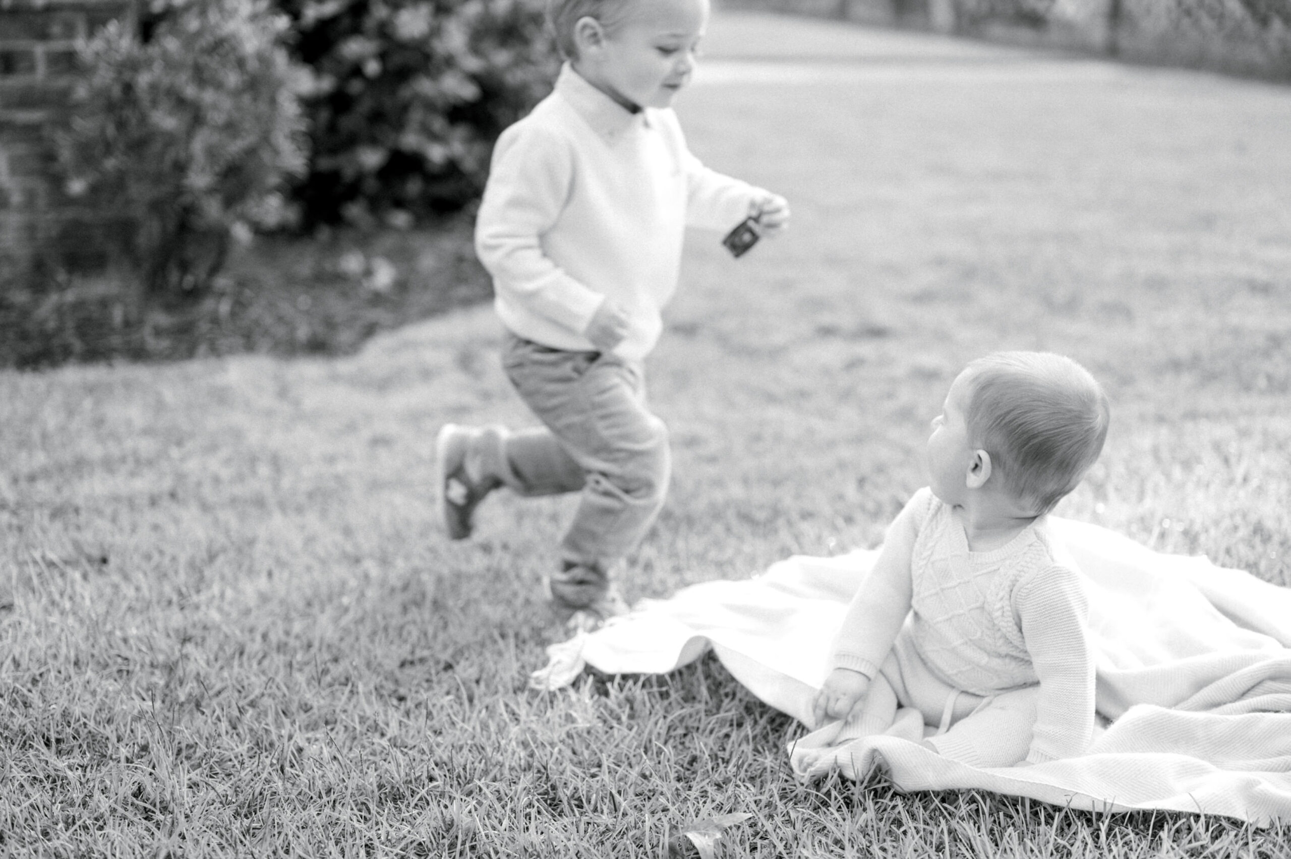 two little boys on a blanket in the yard