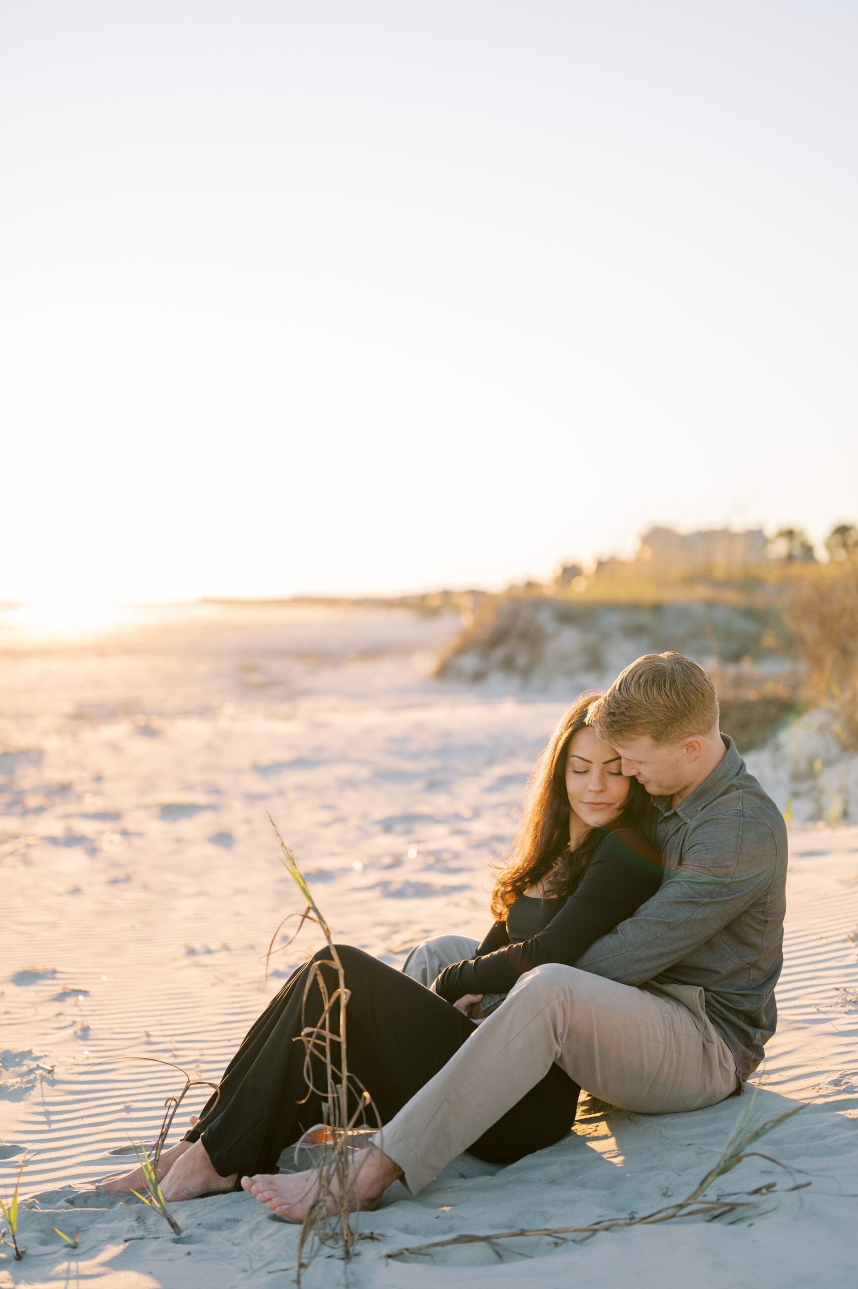 Newly engaged couple sit together on the beach at The Sanctuary on Kiawah Island
