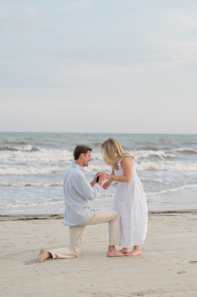 Man proposing to his girlfriend on a beautiful Charleston beach at sunset